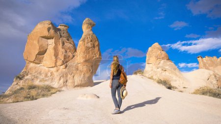 Téléchargez les photos : Femme debout découvre vallée de l'imagination- Cappadoce en Turquie, fond de cheminées de fées - en image libre de droit
