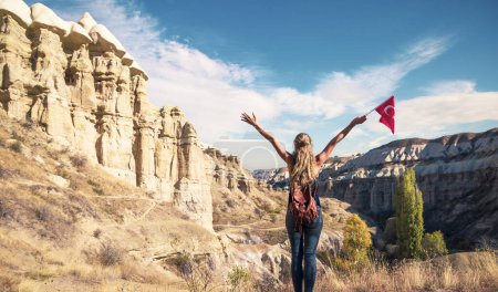 Photo for Tourist female with turkish flag enjoying landscape view of Cappadocia, valley, canyon- Turkey - Royalty Free Image