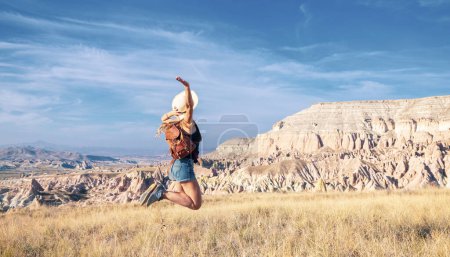 Téléchargez les photos : Happy traveler woman jumping in Cappadocia- Aventure, voyage en voiture, concept de destination de trave en Turquie - en image libre de droit