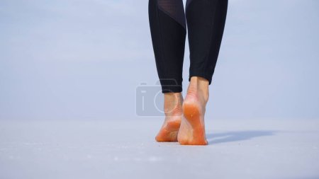 Téléchargez les photos : Gros plan des pieds de la femme Femme marchant pieds nus sur les plaines salées lac - en image libre de droit