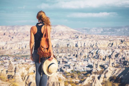 Téléchargez les photos : Vue arrière de la femme touriste explorer la vallée avec des cheminées de fées en Cappadoce-Voyage, tourisme, vacances en Turquie - en image libre de droit