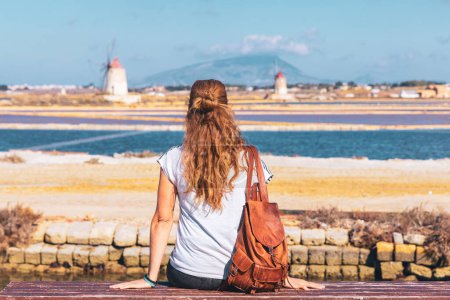 Téléchargez les photos : Femme touriste à Marsala, sel de mer avec moulin à vent typique- Sicile en Italie - en image libre de droit