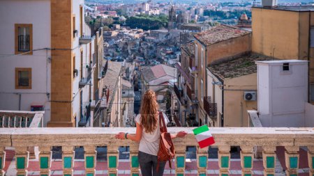 woman on blacony looking at panoramic view of caltagirone, Sicily island in Italy