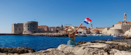 Foto de Una chica con bandera disfrutando de la ciudad de Dubrovnik en Croacia - Imagen libre de derechos