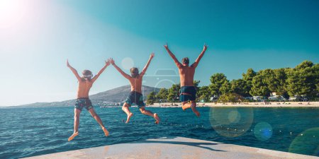 Photo for Happy family jumping together into water- beach,sea,vacation,summer holiday, play and fun concept - Royalty Free Image