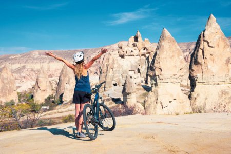 Téléchargez les photos : Femme heureuse avec les bras levés et VTT (Cappadoce) - en image libre de droit