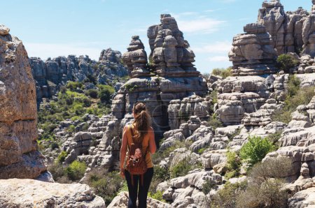 Téléchargez les photos : Vue arrière d'une touriste avec sac jouissant d'un paysage roche géologique naturelle (torcal) Andalousie en Espagne - en image libre de droit