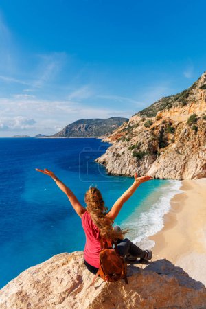 Téléchargez les photos : Jeune femme avec les bras levés et sac profitant de la belle plage en Turquie, Antalya - en image libre de droit