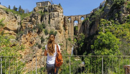 Téléchargez les photos : Vue arrière de touriste femelle regardant la vue célèbre pont dans la ville de Ronda Espagne - en image libre de droit
