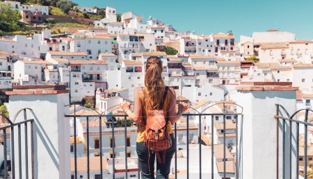 Téléchargez les photos : Vue arrière du touriste féminin qui regarde la vue sur Setenil de las Bodegas, village blanc en Espagne, près de Ronda, Malaga - en image libre de droit