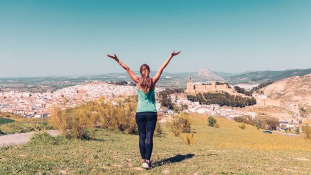 Téléchargez les photos : Vue arrière d'une jeune touriste jouissant d'une vue panoramique sur la ville d'Antequera avec château- Analusie, Espagne, Malaga - en image libre de droit