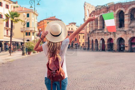 Photo for Rear view of woman holding Italian flag in Verna city- Travel destination, tour tourism in Italy, Europe - Royalty Free Image