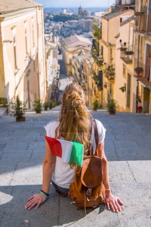 Mujer turista con bolso y bandera en Sicilia, Caltagirona- Italia