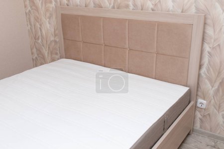 Téléchargez les photos : Beige soft modern bed with upholstered headboard in interior. - en image libre de droit