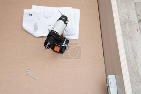 Téléchargez les photos : Assembling a new furniture using a screwdriver - en image libre de droit