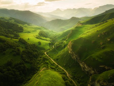 Téléchargez les photos : Vue sur les montagnes verdoyantes et les collines au coucher du soleil. Beau paysage d'été. Le col Aktoprak dans le Caucase du Nord, Russie. - en image libre de droit