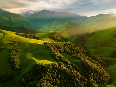 Téléchargez les photos : Montagnes vertes et collines au coucher du soleil. Beau paysage d'été. Le col Aktoprak dans le Caucase du Nord, Russie. - en image libre de droit