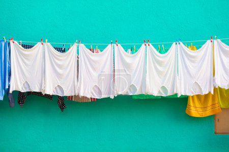 Téléchargez les photos : White laundry is dried outside. Colorful architecture of Burano island, Venice, Italy - en image libre de droit