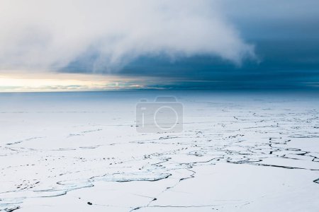 Melting ice on Baikal lake in spring. Clouds over the lake at sunrise. Baikal lake, Siberia, Russia. Abstract nature background. 
