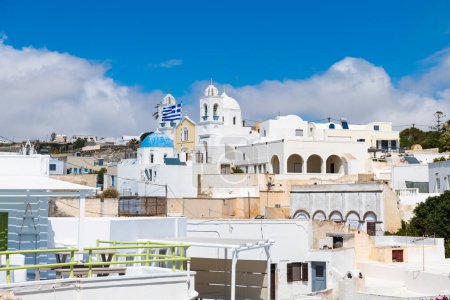 White cycladic architecture in Megalochori village, Santorini island, Greece. Beautiful cityscape at sunny day, white buildings against the blue sky