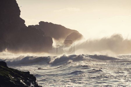 Große Meereswellen krachen im portugiesischen Nazare auf die Felsen. Schöner Strand am Atlantik bei Sonnenuntergang