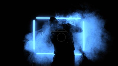 Silhouette of man in smoke and neon lights