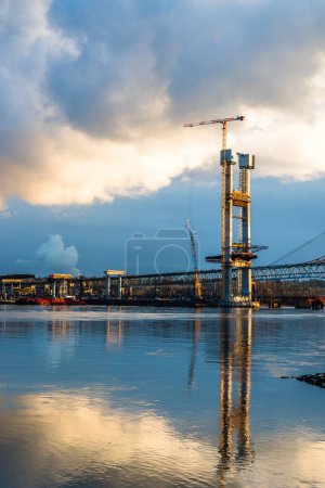 Photo for Construction of a new bridge over the Fraser River from New Westminster City to Surrey City. Beautiful reflection in the water against the background of a cloudy sky - Royalty Free Image