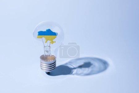 La lámpara de bombilla de vidrio con un mapa ucraniano amarillo-azul en el interior. Fuerte concepto de ucranianos.