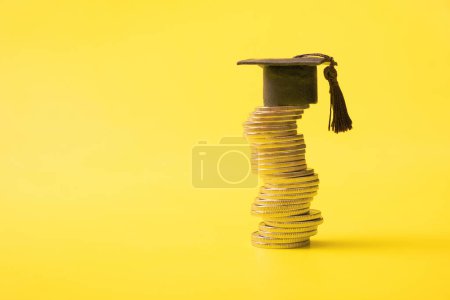 Photo for Graduated cap with coins on yellow background. Savings for education concept. Copy space. - Royalty Free Image