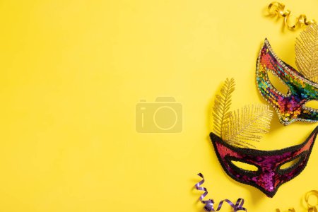Foto de Festive face mask for carnival celebration on yellow background. Copy space. Carnival flat lay. - Imagen libre de derechos