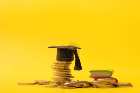 Photo for Graduated cap with coins on yellow background. Savings for education concept. - Royalty Free Image