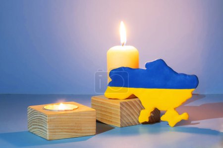 Téléchargez les photos : Map of Ukraine with candle flames on a colored background. - en image libre de droit
