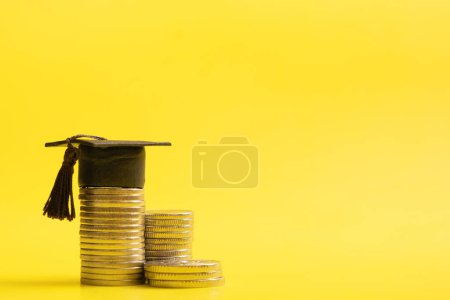 Photo for Graduated cap with coins on yellow background. Savings for education or financial literacy concept. Copy space - Royalty Free Image