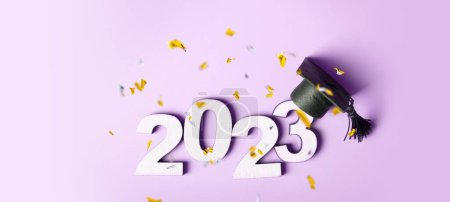 Foto de Clase de concepto 2023. Número de madera 2023 con tapa graduada sobre fondo de color con oropel volador. - Imagen libre de derechos