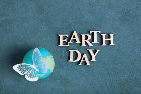 Téléchargez les photos : Texte du jour de la Terre avec globe et papillon. Happy Earth day concept plat, vue de dessus. - en image libre de droit