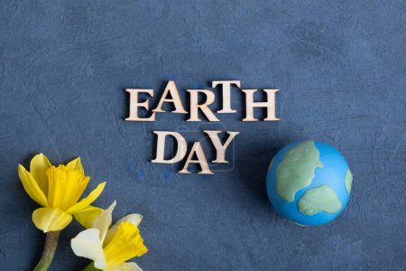 Téléchargez les photos : Texte du jour de la Terre avec globe et fleurs. Happy Earth day concept plat, vue de dessus. - en image libre de droit