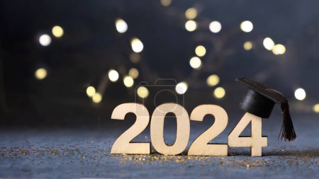 Class of 2024 concept. Number 2024 with graduated cap and bokeh lights banner-stock-photo