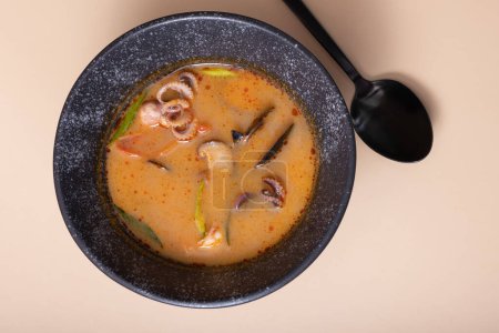 Close up Tom Yum soup with seafood top view. Octopuses and shells in soup