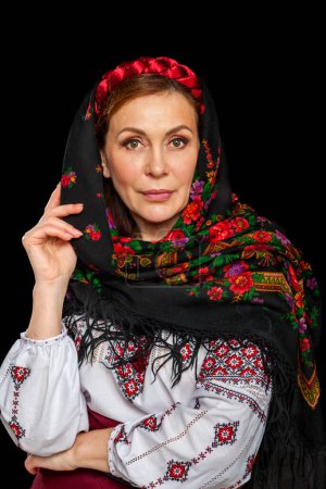 Foto de Hermosa mujer ucraniana en traje nacional. Atractiva mujer ucraniana vestida con bordados tradicionales ucranianos, aislada en el fondo negro. - Imagen libre de derechos