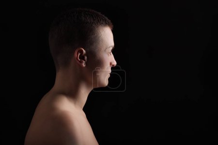 Photo for Portrait of young woman with short hair and bare shoulder, on black bakground - Royalty Free Image