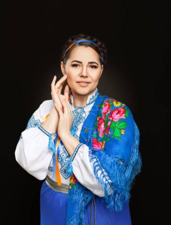 Foto de Hermosa mujer ucraniana en traje nacional. Atractiva mujer ucraniana vistiendo en tradicional bordado ucraniano vyshyvanka, en el fondo negro. - Imagen libre de derechos