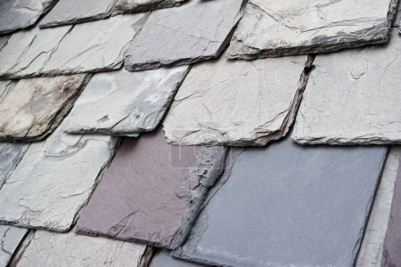 Weathered slate roof tiles on a historic building. Slate is an exceptionally durable traditional roofing material.