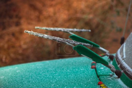 Téléchargez les photos : Frozen lift up front wind glass wipers on green retro car at winter season - en image libre de droit