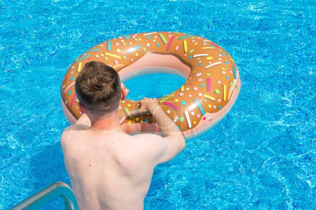Foto de Joven con anillo de goma en la piscina suumer - Imagen libre de derechos