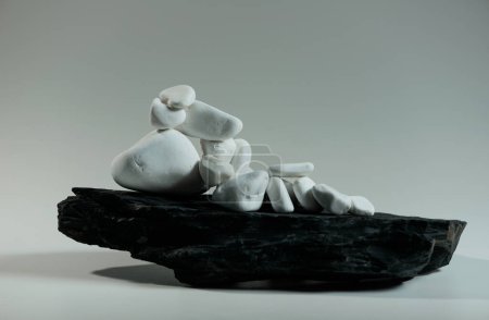 Foto de Piedras lisas blancas se encuentran al azar sobre una piedra plana negro - Imagen libre de derechos