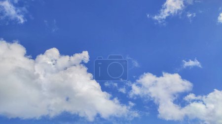 Mesmerizing cloudscape, with fluffy white cumulus clouds drifting across a vibrant blue sky