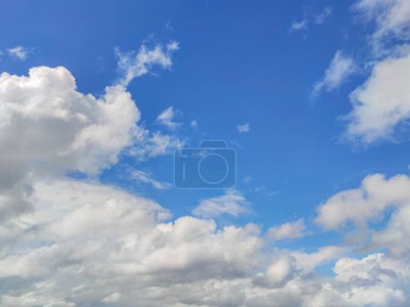 Mesmerizing cloudscape, with fluffy white cumulus clouds drifting across a vibrant blue sky