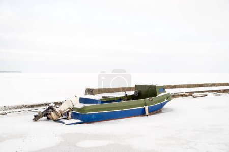 Foto de Vieja lancha solitaria en un puerto congelado en invierno, paisaje nevado, mucho espacio de copia en la parte superior - Imagen libre de derechos
