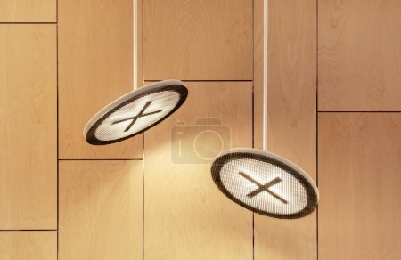 Foto de Dos lámparas de techo de diseño moderno contra pared de madera, equipo de iluminación led interior contemporáneo - Imagen libre de derechos