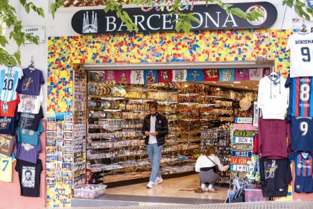 Foto de Barcelona, España - 01 de mayo de 2023: Tienda de souvenirs tradicional en Barcelona, España con turistas buscando regalos - Imagen libre de derechos